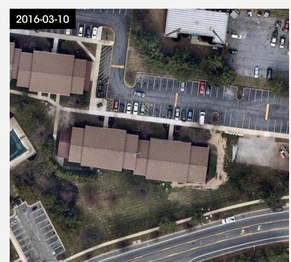 Timestamped satellite image dated March 2016 showing the apartment building's roof and adjacent parking lot.